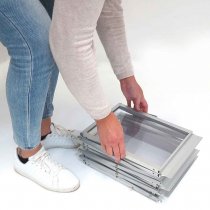 Person som fäller upp broschyrställ Smarter med saxkonstruktion i aluminium