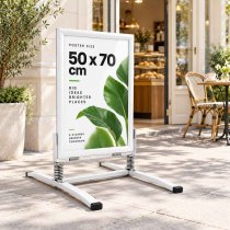 Vit trottarpratare Wind utanför café med 50x70 reklam