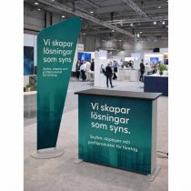 Banner i textel på fistående stativ i mässhall